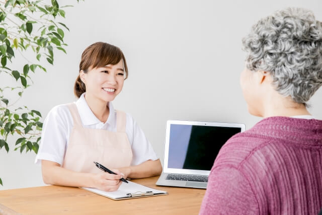 介護士が笑顔で高齢者と会話する