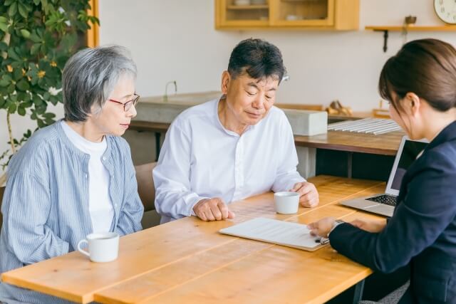 高齢者がテーブルで専門家と相談