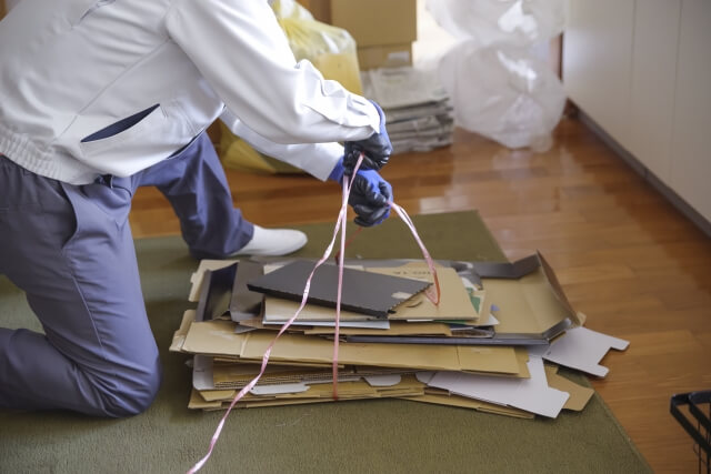 段ボールを片付ける作業員の手元