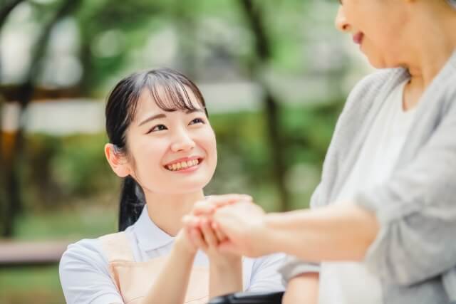 若者が公園で高齢者と笑顔で会話
